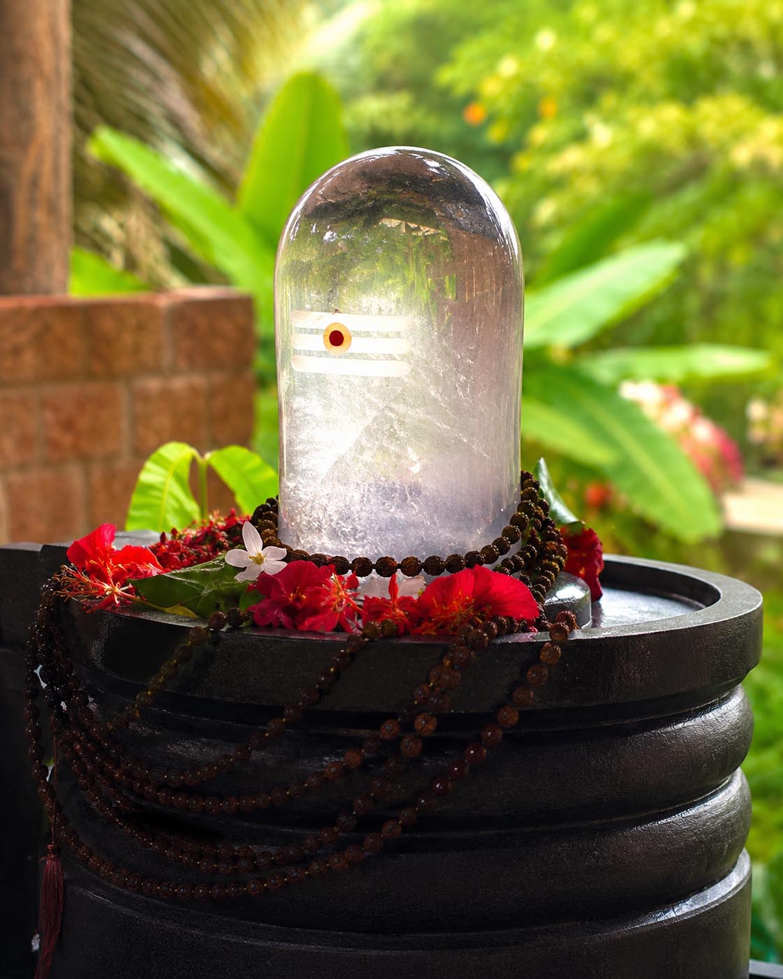 Close-up of a natural clear quartz Sphatik Shivling on a brass puja plate